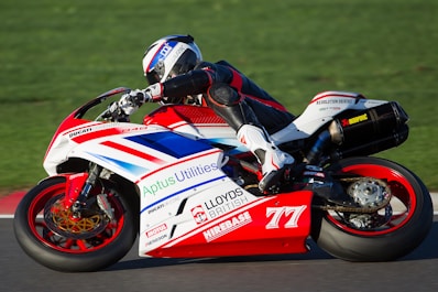 person riding red and white sportbike