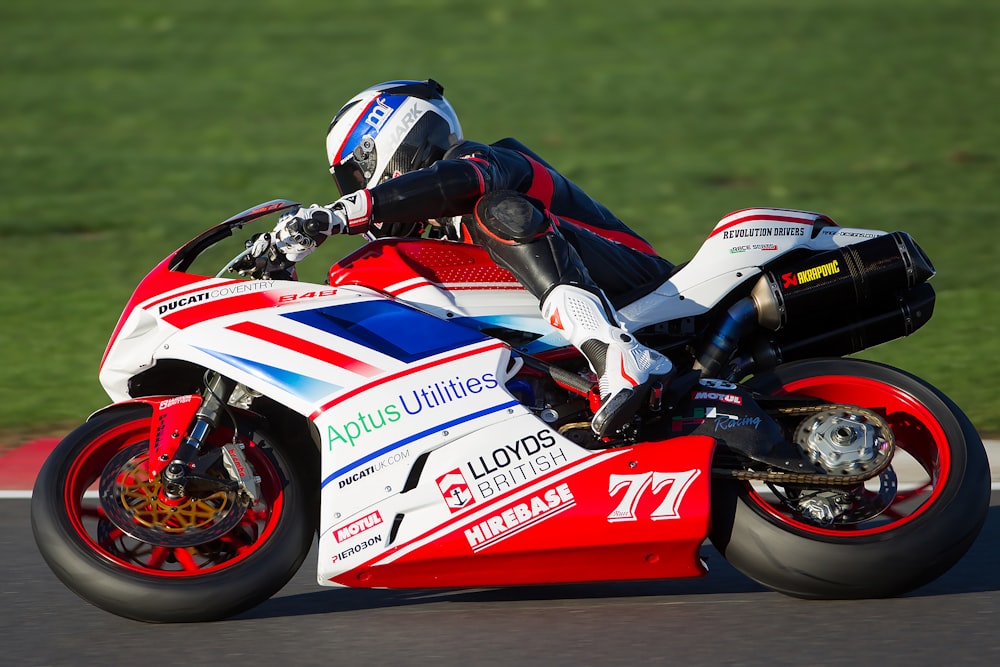 person riding red and white sportbike