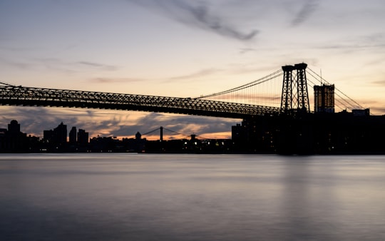 photo of bridge near body of water during night time in Williamsburg Bridge United States