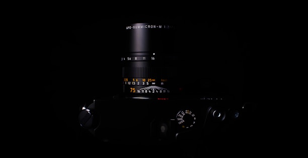 Close-up of a high-end camera lens capturing vibrant visuals against a moody, black backdrop.
