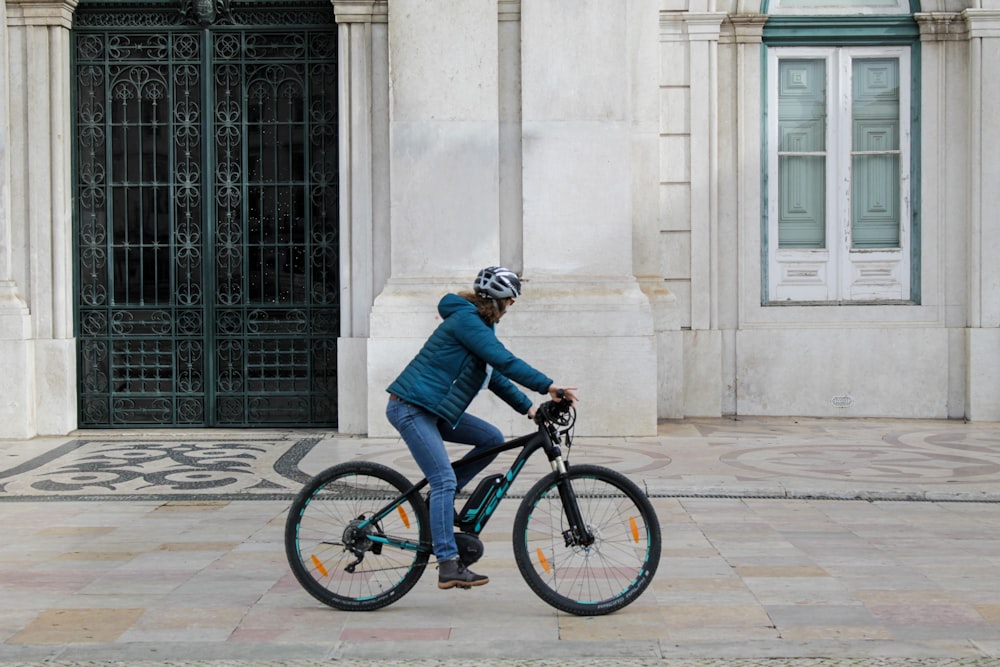 person riding on bicycle near building