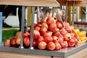 Bright red pomegranates paired with a cluster of green grapes on a table