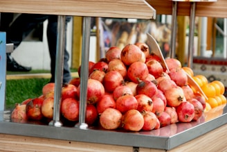 Bright red pomegranates paired with a cluster of green grapes on a table