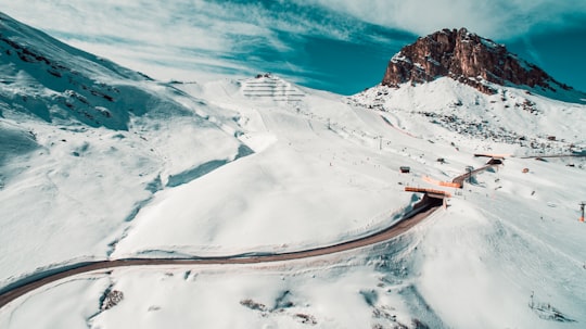 aerial view of road surrounded by mountain covered by snow in Canazei Italy