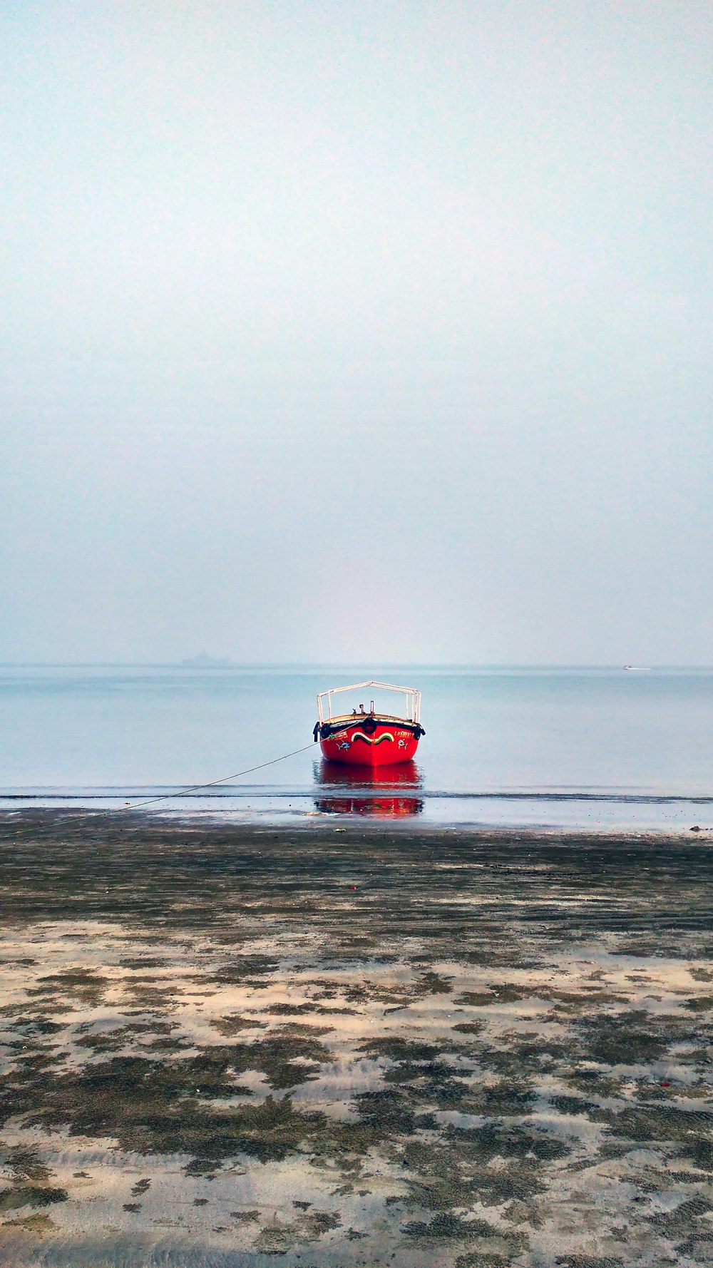 red and black boat on seashore