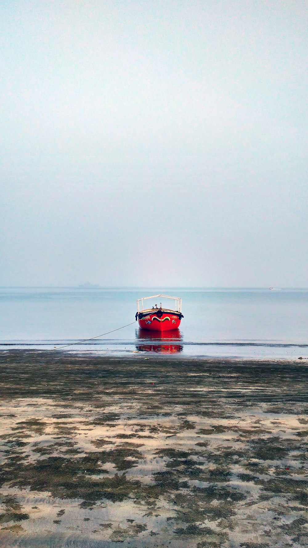 Rotes und schwarzes Boot am Meer