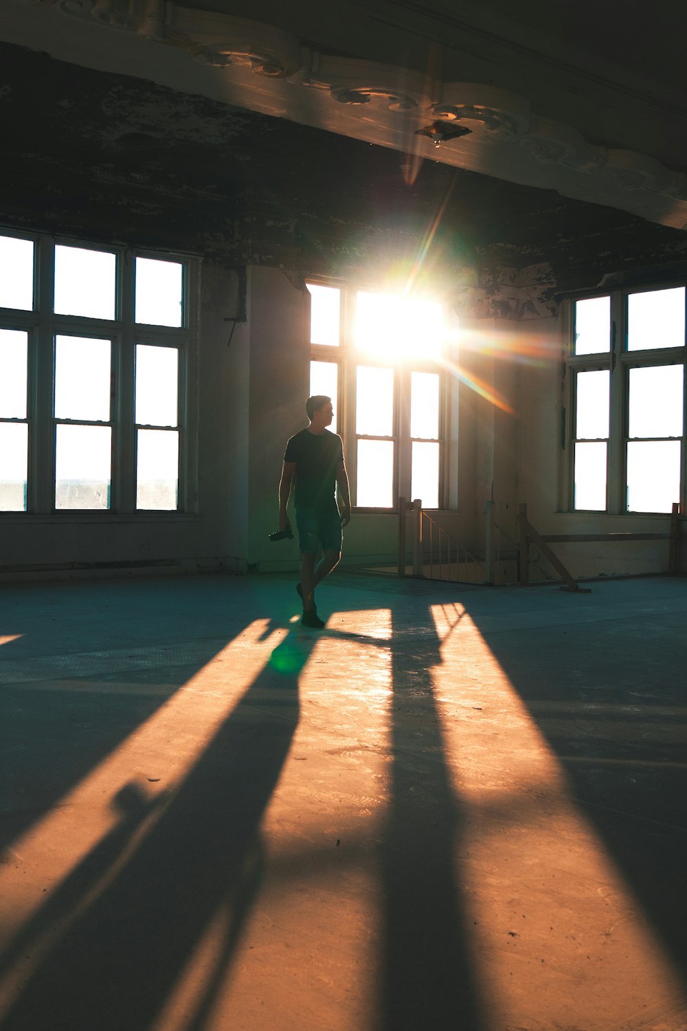 man standing near stairs and windows during daytime