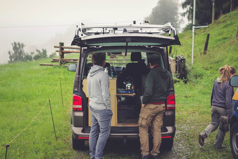 people standing at the back on an open vehicle