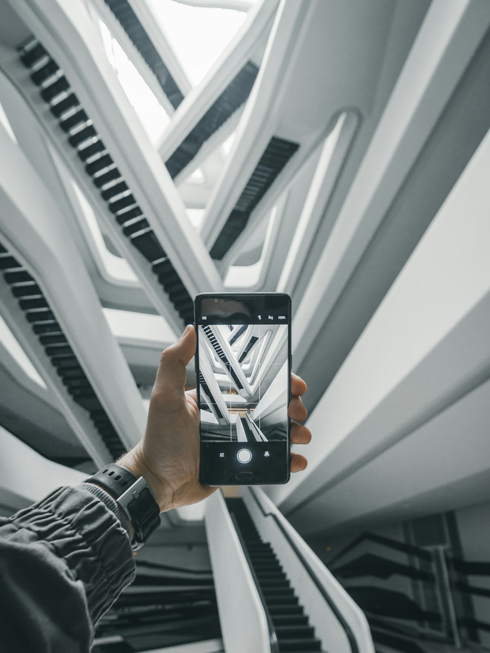 person taking a photo of escalators in building