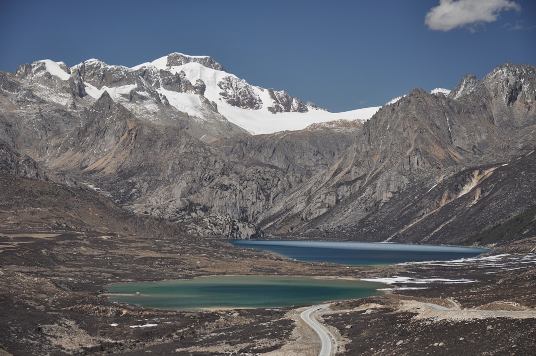 two lakes near road in distant of snow capped mountain in Litang China