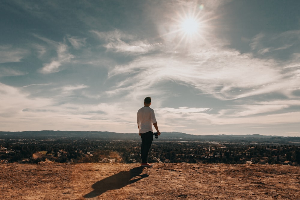 man standing overlooking concrete buildings