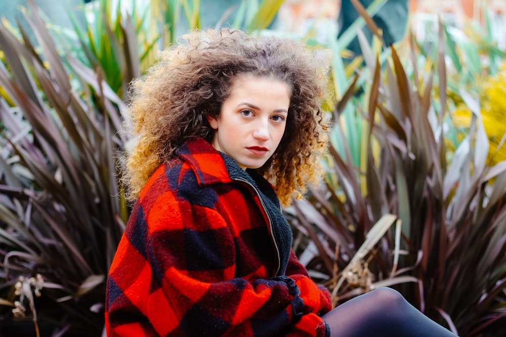 woman sitting beside black plant