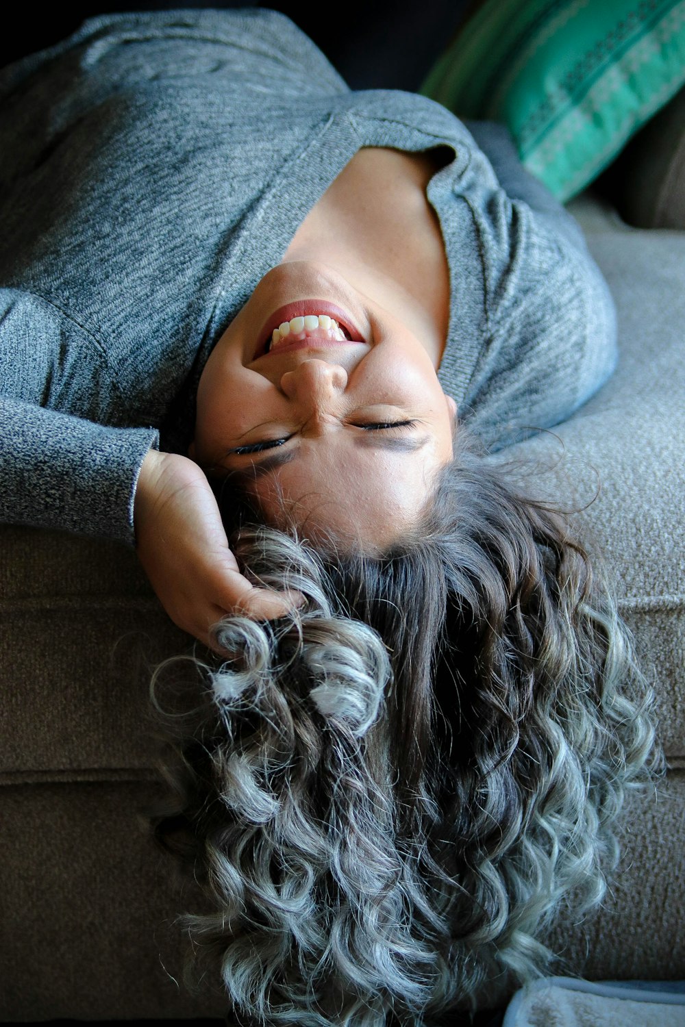 woman laying on couch near throw pillow