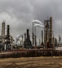 factories with smoke under cloudy sky