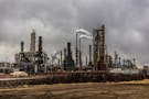 factories with smoke under cloudy sky