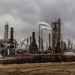 factories with smoke under cloudy sky