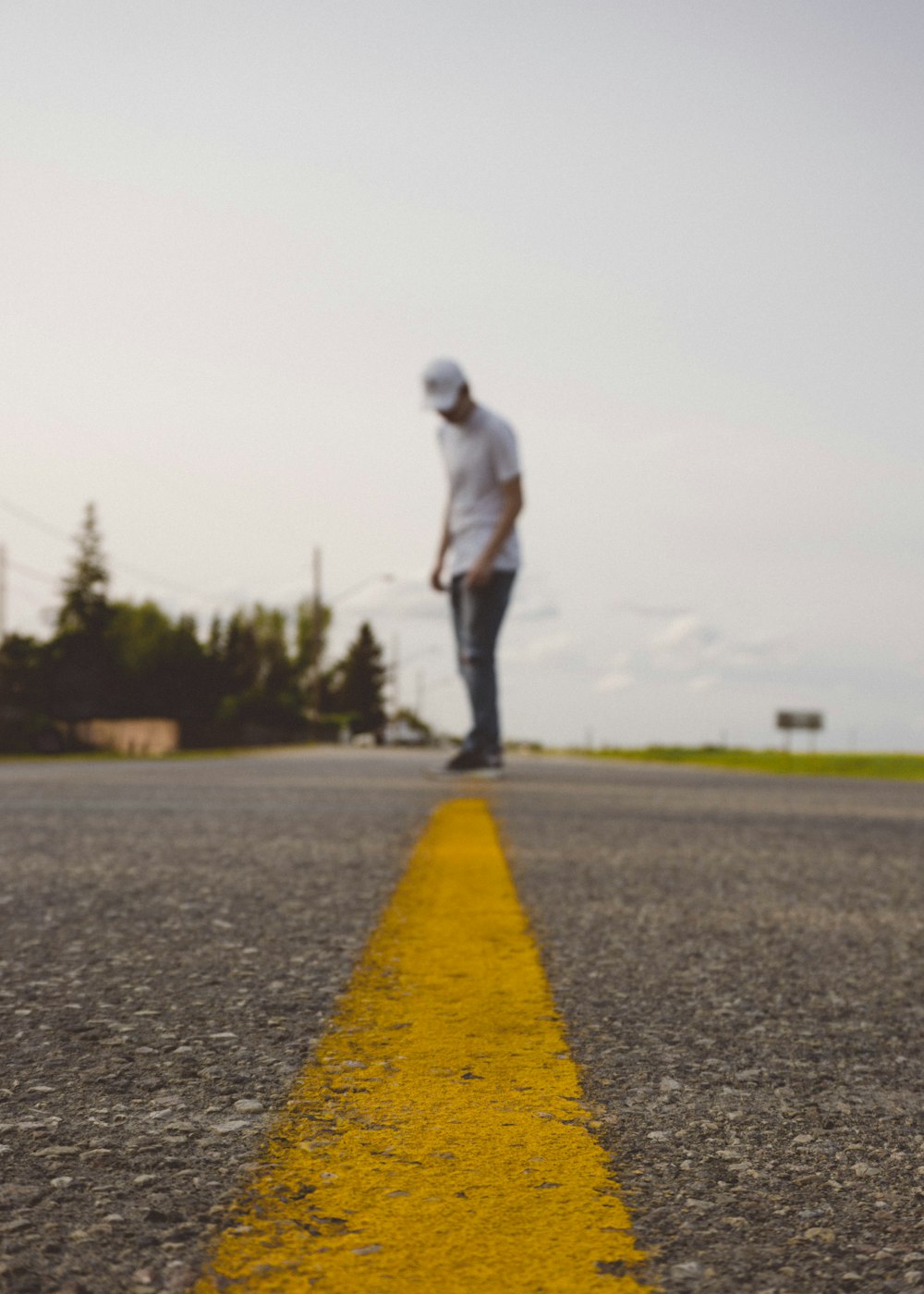 man standing on gray road