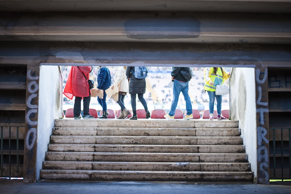 six person walking near tunnel