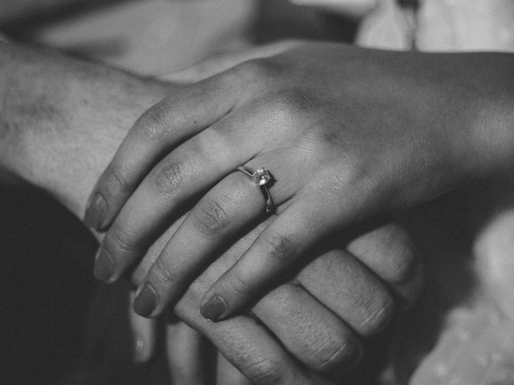 grayscale photography of human hands holding together