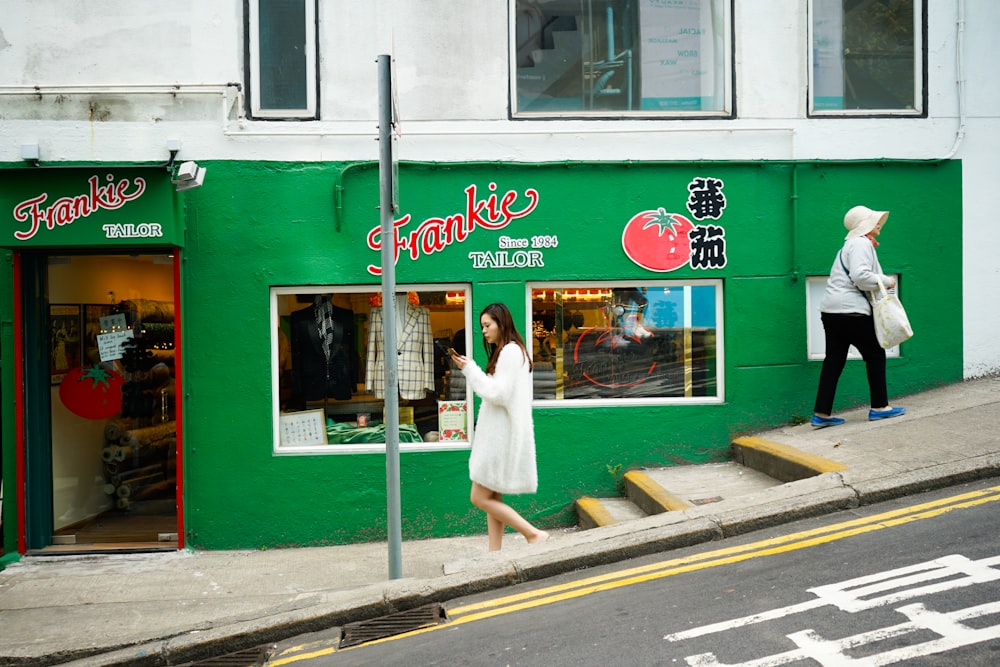 woman wearing white dress walking near building during daytime