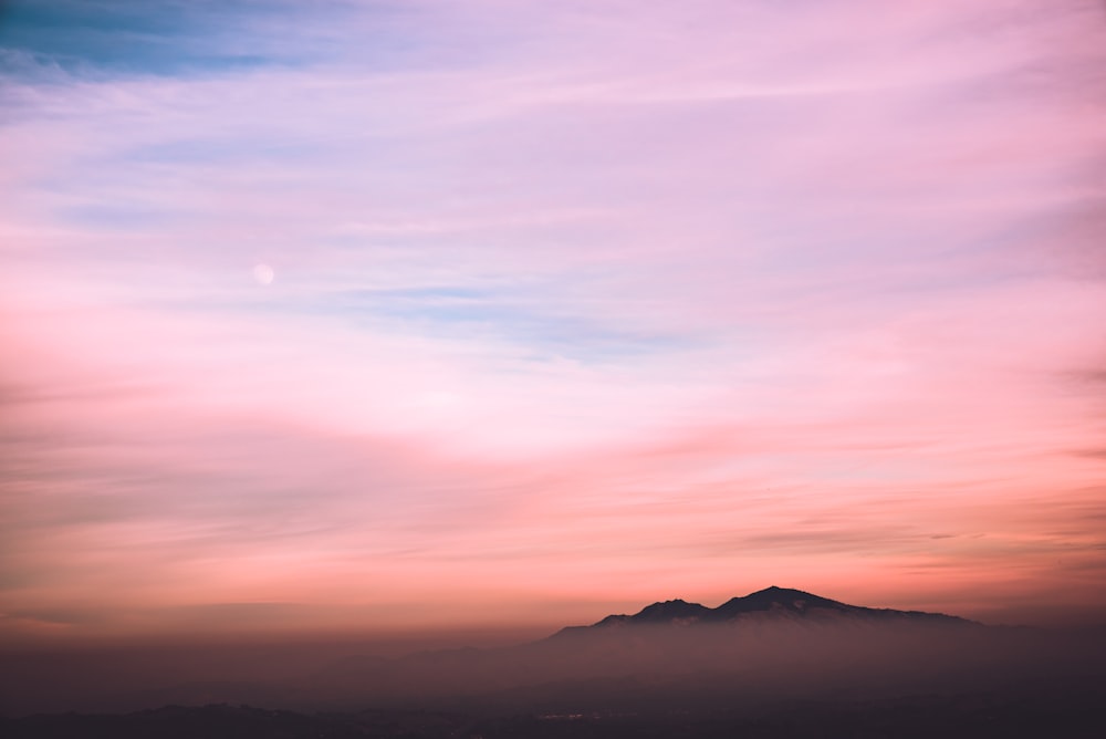 black mountain under blue and white sky