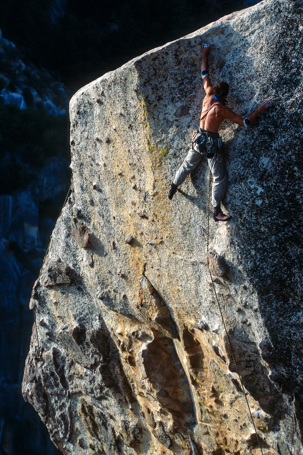 Uomo che si arrampica sulla collina rocciosa durante il giorno