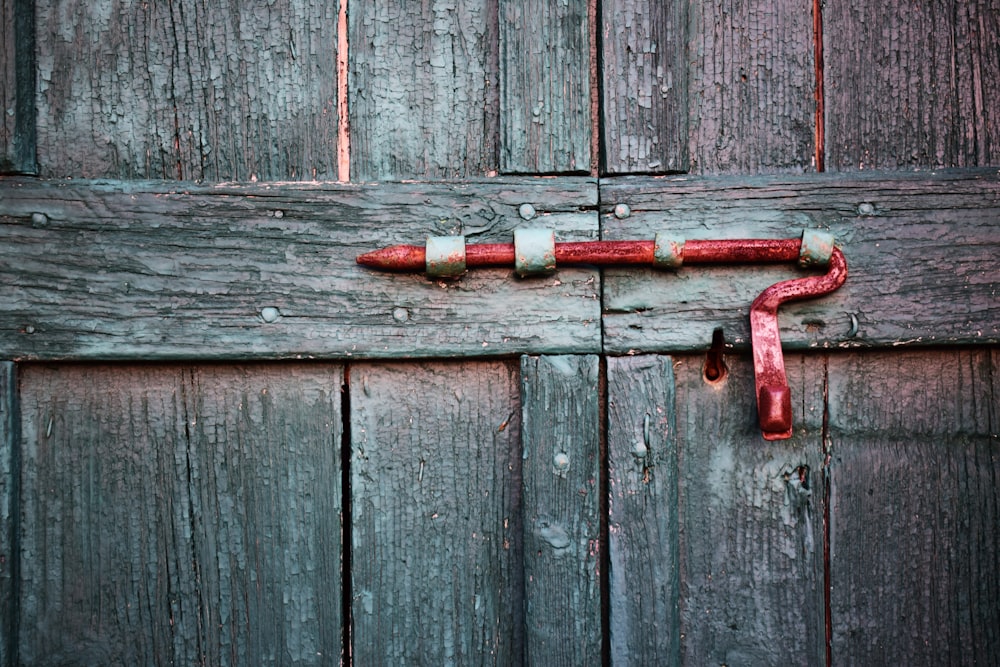 Puerta de madera beige con cerradura roja