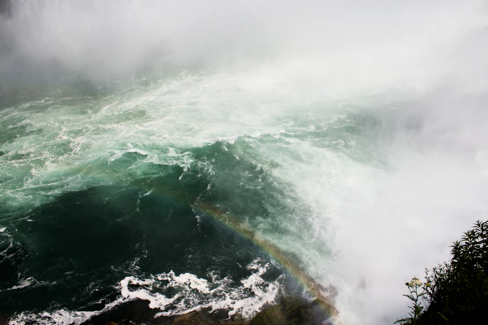 Dramatic scene at Niagara Falls with powerful waterfall cascading down into pool below