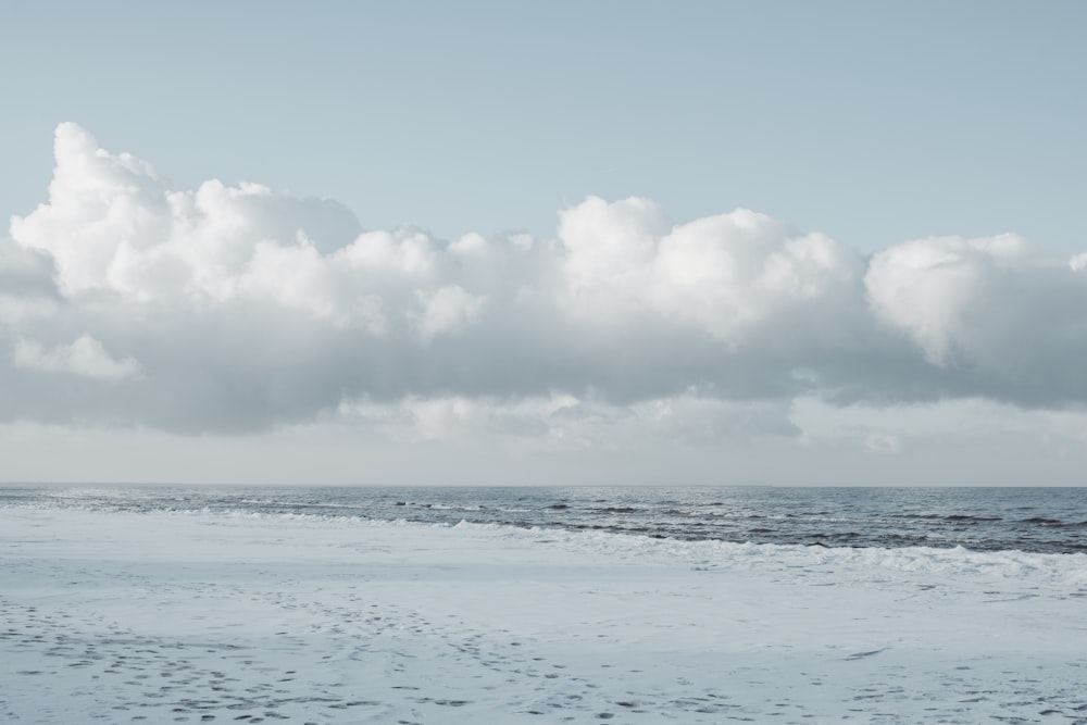 clear body of water under white clouds