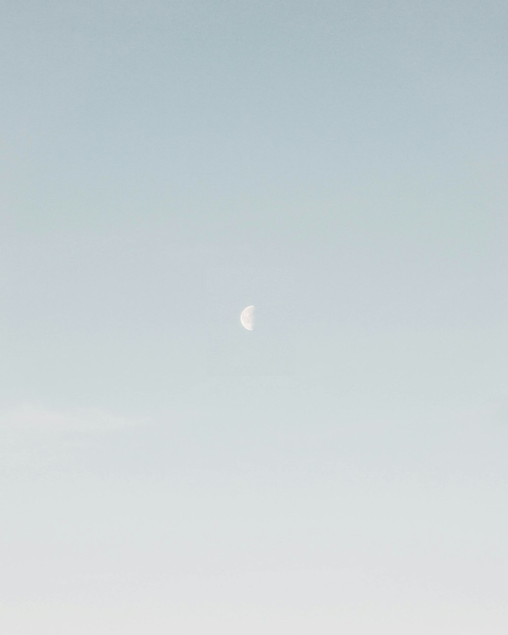photo of half-moon during daytime