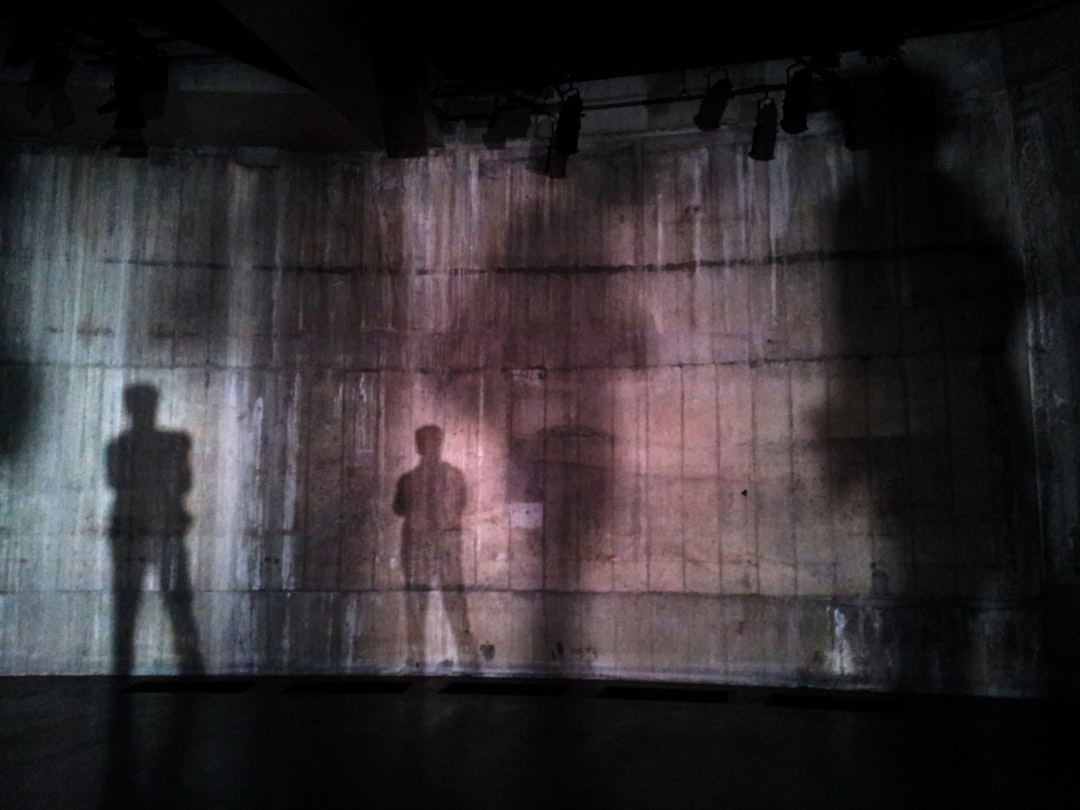 silhouette of man standing near wall on dark area, Shadows