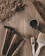 Wood shavings scatter across a wooden surface, accompanied by two hammers, a screwdriver, two paintbrushes, and a cup of tea with a tag. A plane is positioned at the top right, contributing to the woodworking atmosphere.