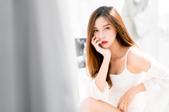 woman wearing lingerie sitting on bed