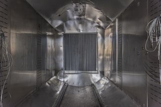 A spacious industrial cold storage room with stainless steel panels and bright lighting.