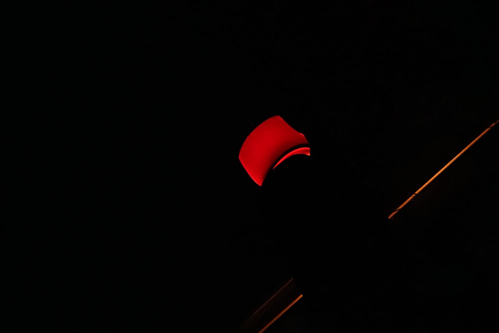 a red umbrella is lit up in the dark