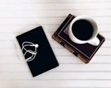 A minimalist workspace with books on strategy, a notebook, and a cup of coffee