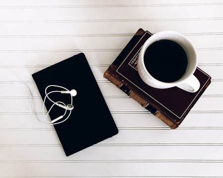 A quiet workspace with a cup of coffee and marketing books stacked neatly.
