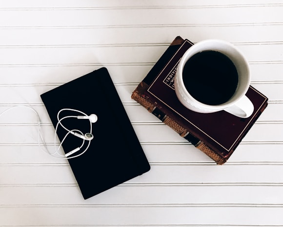 A minimalist office setting with design books and a coffee cup.