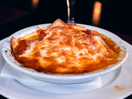 Rustic plate of homemade lasagna served with a side of fresh salad.