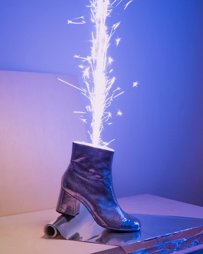 Sleek black leather boots with subtle glowing blue accents on a dark surface