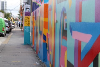 A vibrant city street with colorful graffiti walls and lively urban scenes.