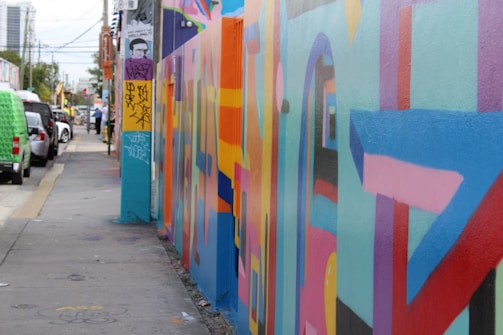 A vibrant, colorful painting capturing a retro Los Angeles street scene with quirky characters and bold shapes.