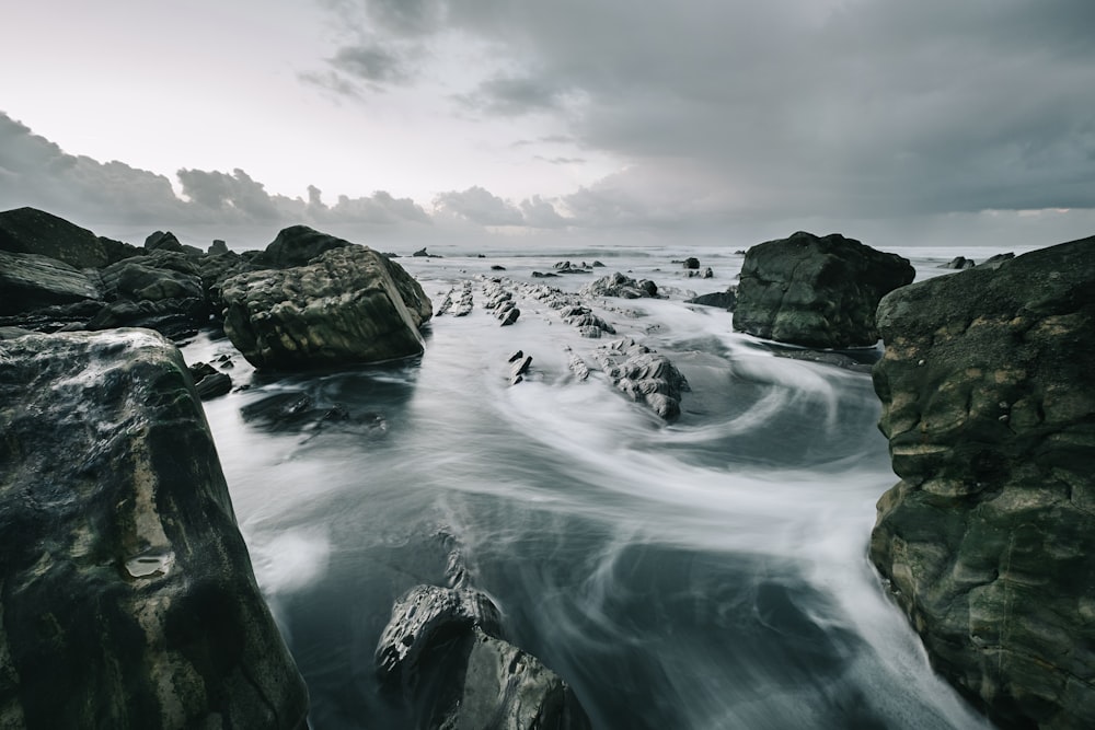 brown rock and cliff surrounded body of water