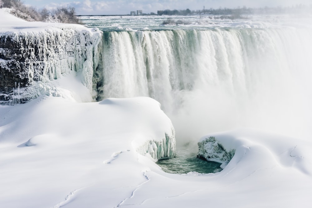 landscape photo of waterfall and snow during daytime