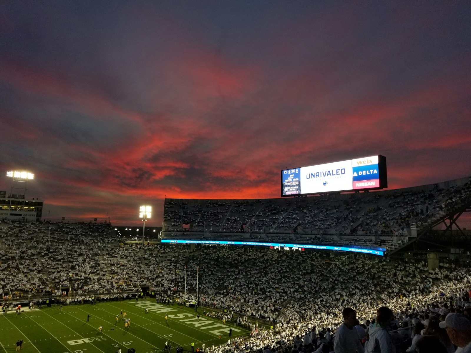 A full college football stadium at sunset