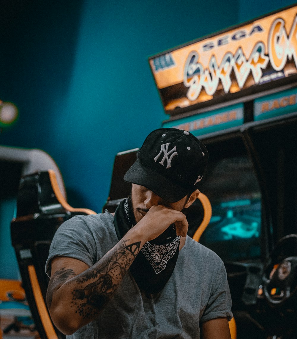 man sits near racing arcade machine