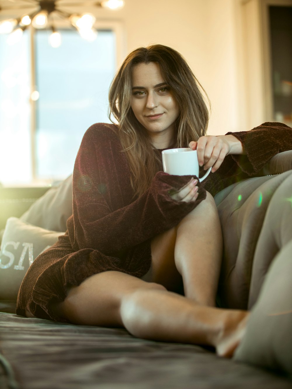 woman wearing maroon sweater sitting on sofa