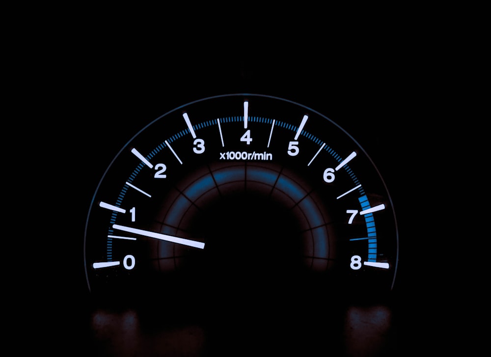 white and blue analog tachometer gauge