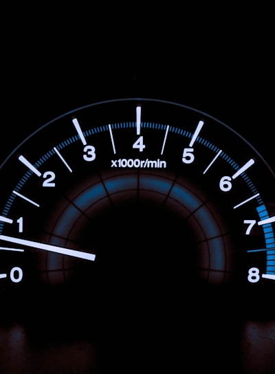 white and blue analog tachometer gauge