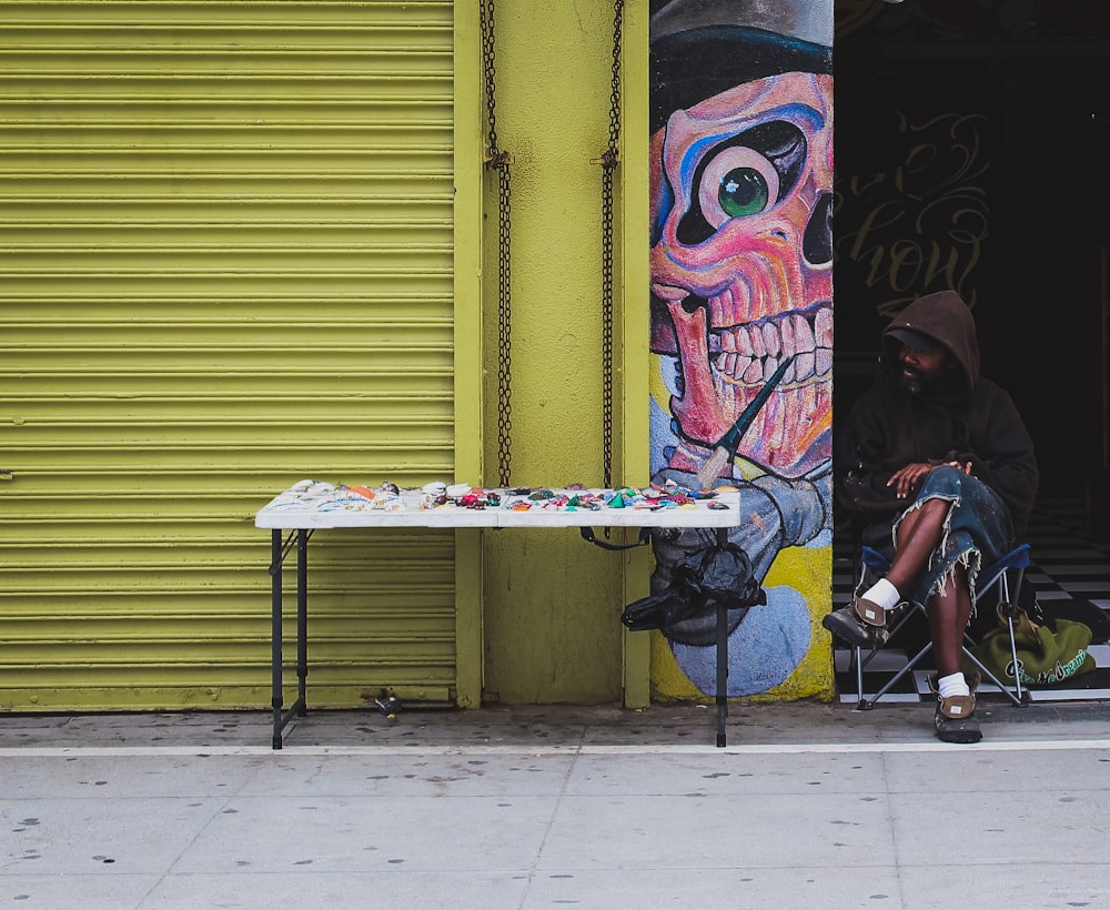 man in brown hoodie sitting beside table